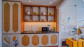 A modern kitchen with a wooden cabinet and a microwave.