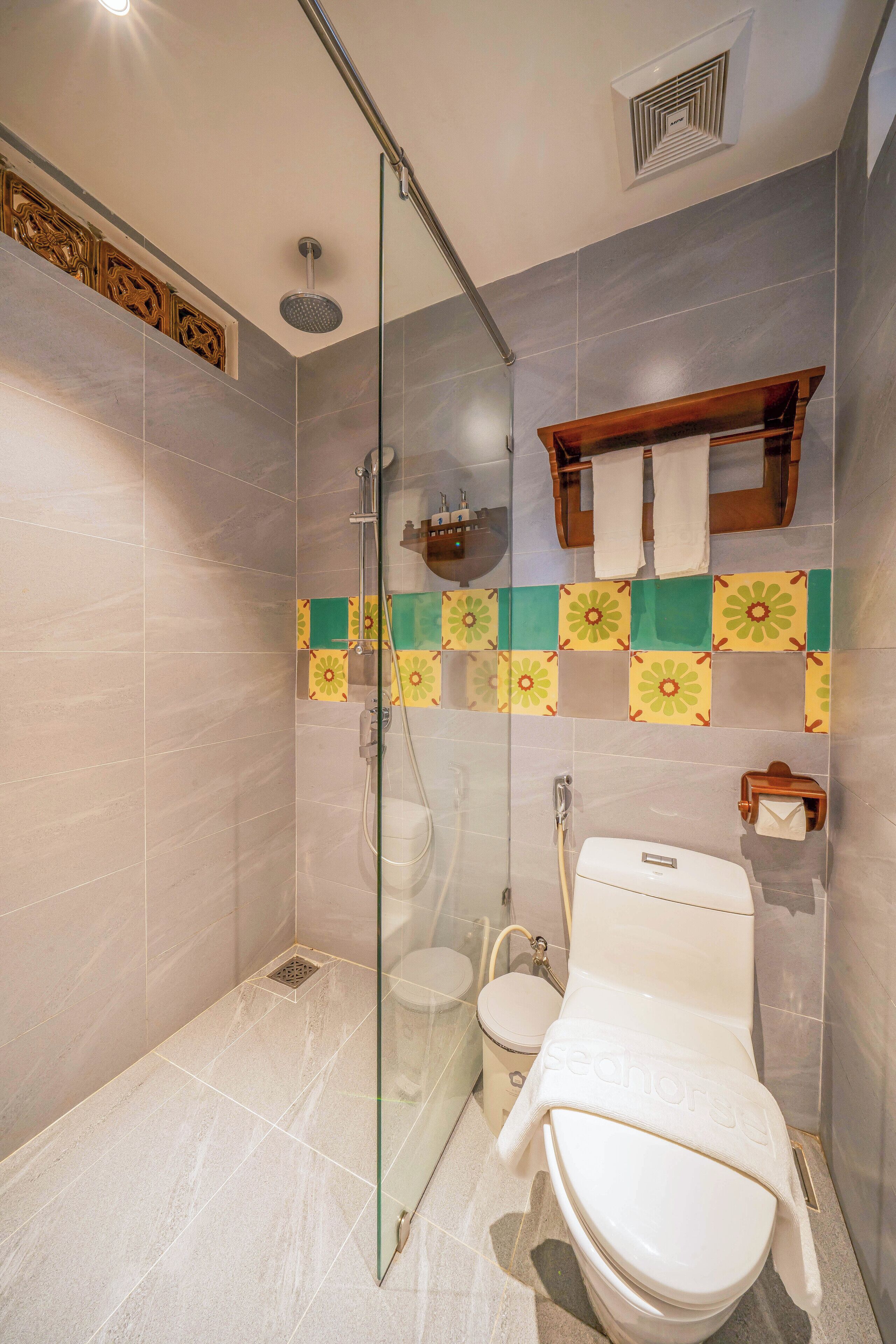 A modern bathroom with a glass-enclosed shower, a toilet, and a sink.