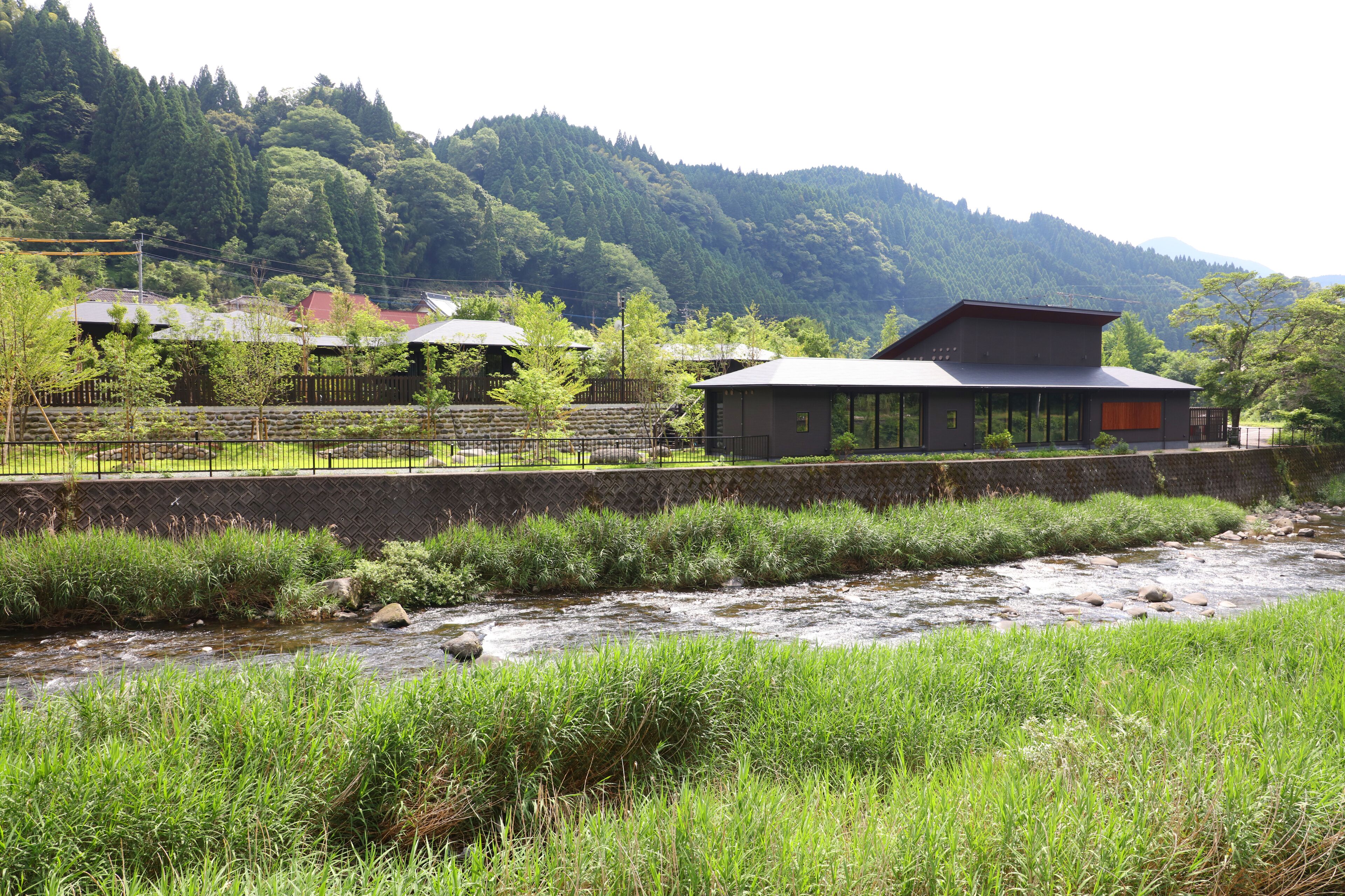 A riverside hotel with a view of a mountain range.