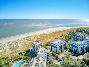 An aerial view of a coastal hotel with multiple buildings, a beach, and a swimming pool. - Fully Renovated 2025 | Oceanfront 2BR in Wild Dunes (Isle of Palms)