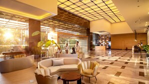 A spacious lobby with a checkered floor, a reception desk, and seating areas. - O by Tamara Coimbatore (Coimbatore)