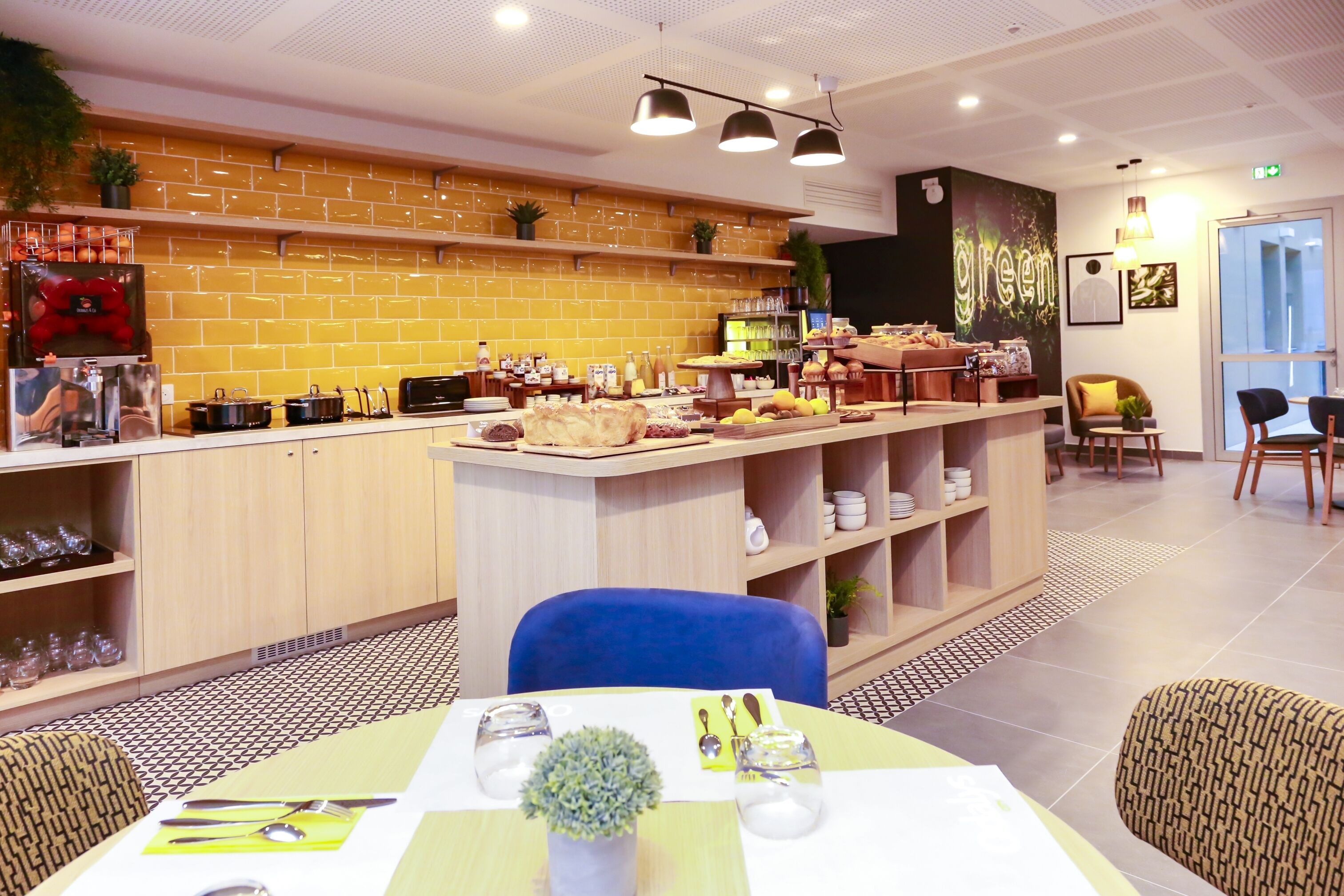 A modern restaurant with a brick wall, a bar area, and a seating section with tables and chairs.