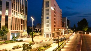 A modern building with multiple floors, large windows, and a well-lit entrance area. - Appart Hotel Odalys City Angers Centre Gare (Angers)