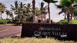 A sign for Waikoloa Colony Villas with a stone wall and palm trees in the background. - Private townhome near Hawaii's best beaches (Waikoloa)