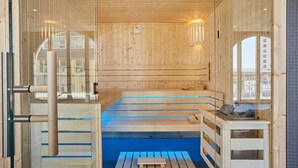 A sauna with wooden walls and a blue floor, featuring a bench and a small table with a basket. - Appart Hotel Odalys City Marseille Centre Euromed (Marseille)