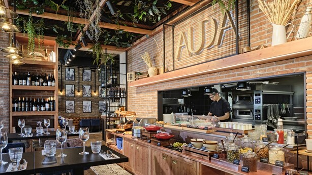 A restaurant with a brick wall, wooden counter, and hanging plants. - Appart Hotel Odalys City Marseille Centre Euromed (Marseille)