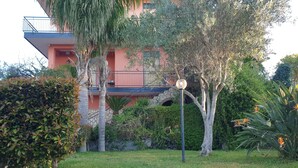 A residential building with a balcony, surrounded by well-maintained greenery and a lawn. - ETNA VIEW-CATANIA-VALVERDE (Maugeri)