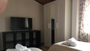 A hotel room with two beds, a TV on a stand, and a wardrobe. - ETNA VIEW-CATANIA-VALVERDE (Maugeri)