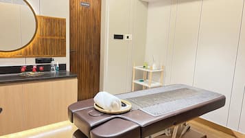 Features a medical examination room with a cabinet, mirror, and examination table.