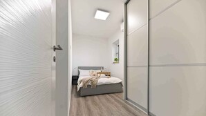 A bedroom with a bed, bedside table, and a nightstand.