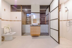 Un baño moderno con inodoro, lavamanos y zona de ducha.