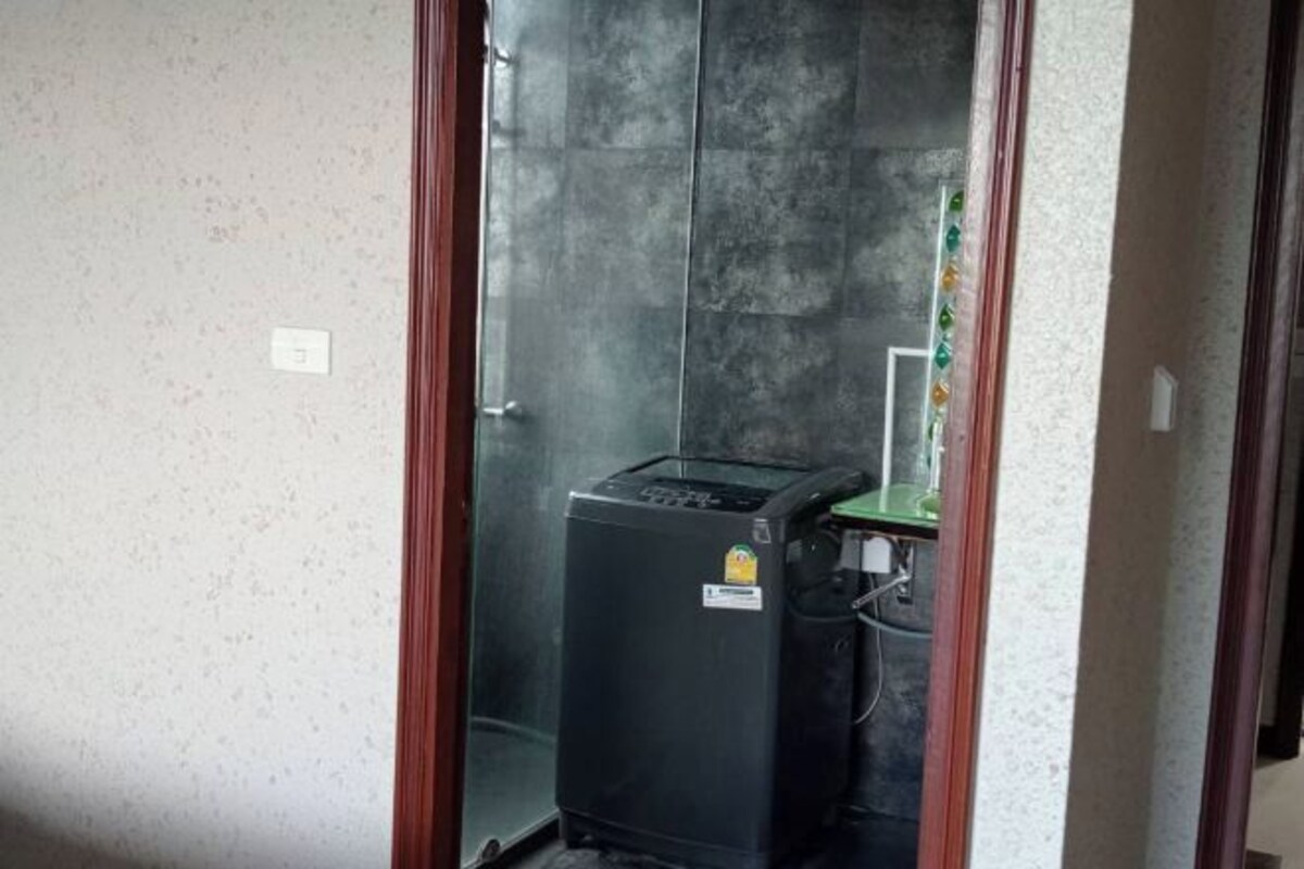 A compact room with a small black appliance, possibly a coffee maker, on a counter.
