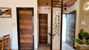 Un intérieur moderne avec des portes en bois, un coin repas et un espace salon.