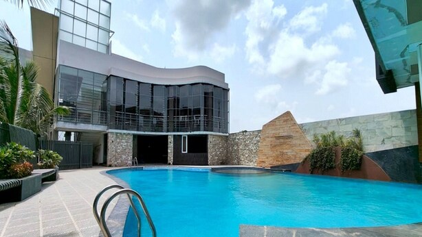 Un bâtiment moderne doté d’une piscine, de murs en pierre et d’une façade en verre.