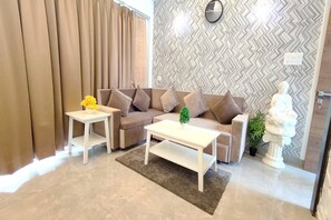 Deluxe Room | Living area | 32-inch LED TV with cable channels, TV