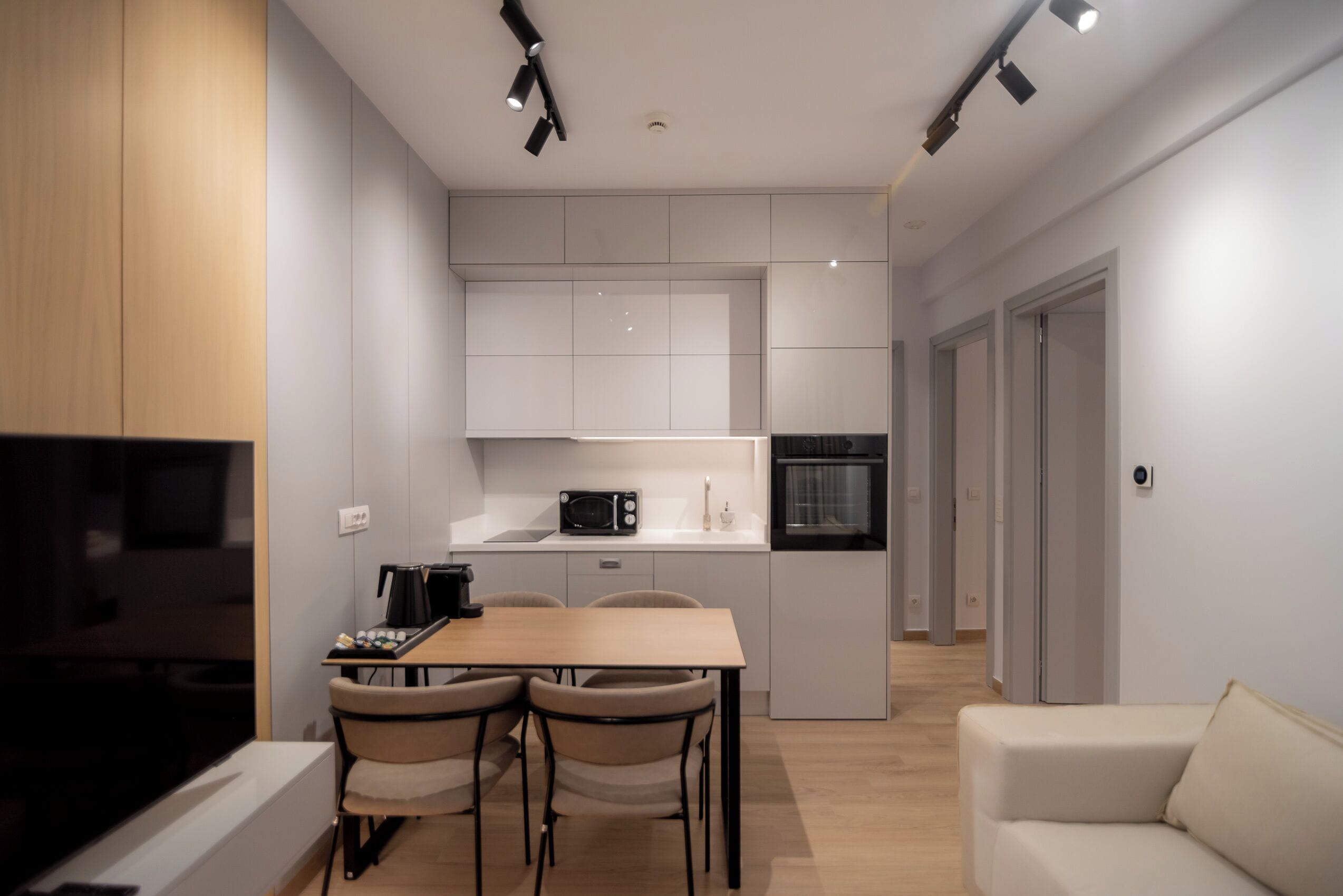Una cocina moderna con comedor, microondas, máquina de café y sofá.