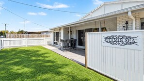 A residential property with a covered patio, a fenced backyard, and a sign reading 'VITAMINSEA'. - Vitamin Sea - Rainbow Beach (Rainbow Beach)