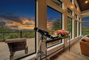 Un télescope installé sur un balcon, offrant une vue sur le ciel nocturne.