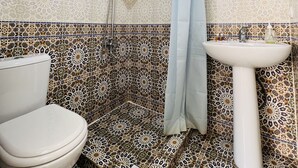 Une salle de bain avec une douche, des toilettes et un lavabo.