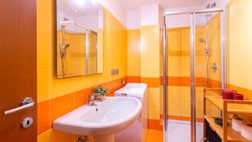 Un bagno con lavandino, specchio, doccia e WC.