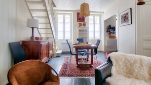 Una sala de estar amplia con una escalera, un comedor y una zona de estar acogedora.