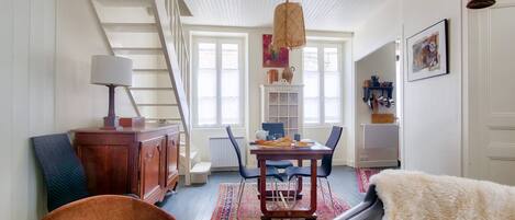 A spacious living room with a staircase, a dining area, and a cozy seating area.