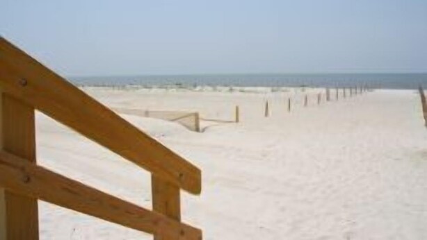A beach with a wooden walkway leading to the sea. - B.E.A.C.H.  Best Escape Anyone Could Have--  Let's Go!!  2 Bedroom / 2 Bath!! (Biloxi)