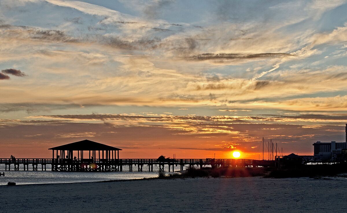 A beach with a pier and a gazebo.