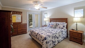 A bedroom with a bed, a wooden dresser, a nightstand, a ceiling fan, and a window with blinds. - B.E.A.C.H.  Best Escape Anyone Could Have--  Let's Go!!  2 Bedroom / 2 Bath!! (Biloxi)