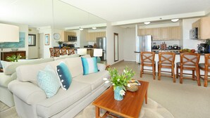 A modern living room with a sofa, coffee table, and dining area with chairs. - Gorgeous Waikiki Ocean View! Full Kitchen, Free Wi-Fi, Close to Beach! (Honolulu)