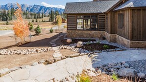 A rustic cabin with a stone pathway leading to the entrance, surrounded by a natural landscape with mountains in the background. - New Luxury home in Cascade Village - 2 miles to Purgatory - AC - Hot Tub/Pool (Durango)