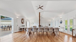 A spacious dining area with a wooden floor, a central table with chairs, and a ceiling fan. - Ultimate family retreat, on the Portsea / Sorrento border, (sleeps 15/16) (Portsea)