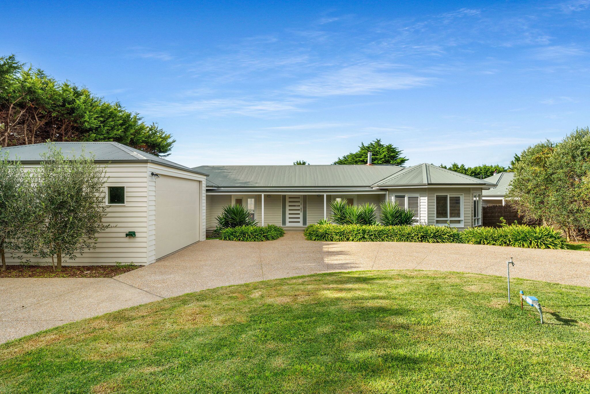 A two-story house with a covered porch, a driveway, and a well-maintained lawn.