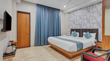 Habitación de hotel con cama de madera, televisor de pantalla plana, cafetera y una silla roja.