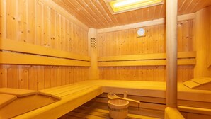 A sauna room with wooden benches and a wooden bucket. - Eibinghof Bed & Breakfast (Saalbach-Hinterglemm)
