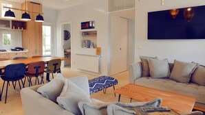 Ein modernes Wohnzimmer mit einer Couch, einem Couchtisch und einem Essbereich mit Stühlen und einem Tisch.