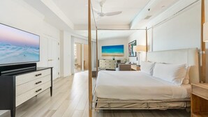 Ein geräumiges Schlafzimmer mit einem Himmelbett, einem Flachbildfernseher, einem Schreibtisch und einem Bild an der Wand.