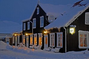 A snow-covered building with multiple windows and a sign that reads "Gull".