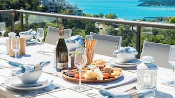 A table set for a meal with a bottle of wine, glasses, and a variety of food items.
