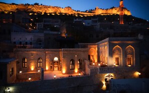 A historic building with arched windows and a courtyard, illuminated by warm lighting.