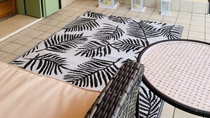 Une pièce avec un lit, une table ronde et trois lanternes blanches posées sur le sol.