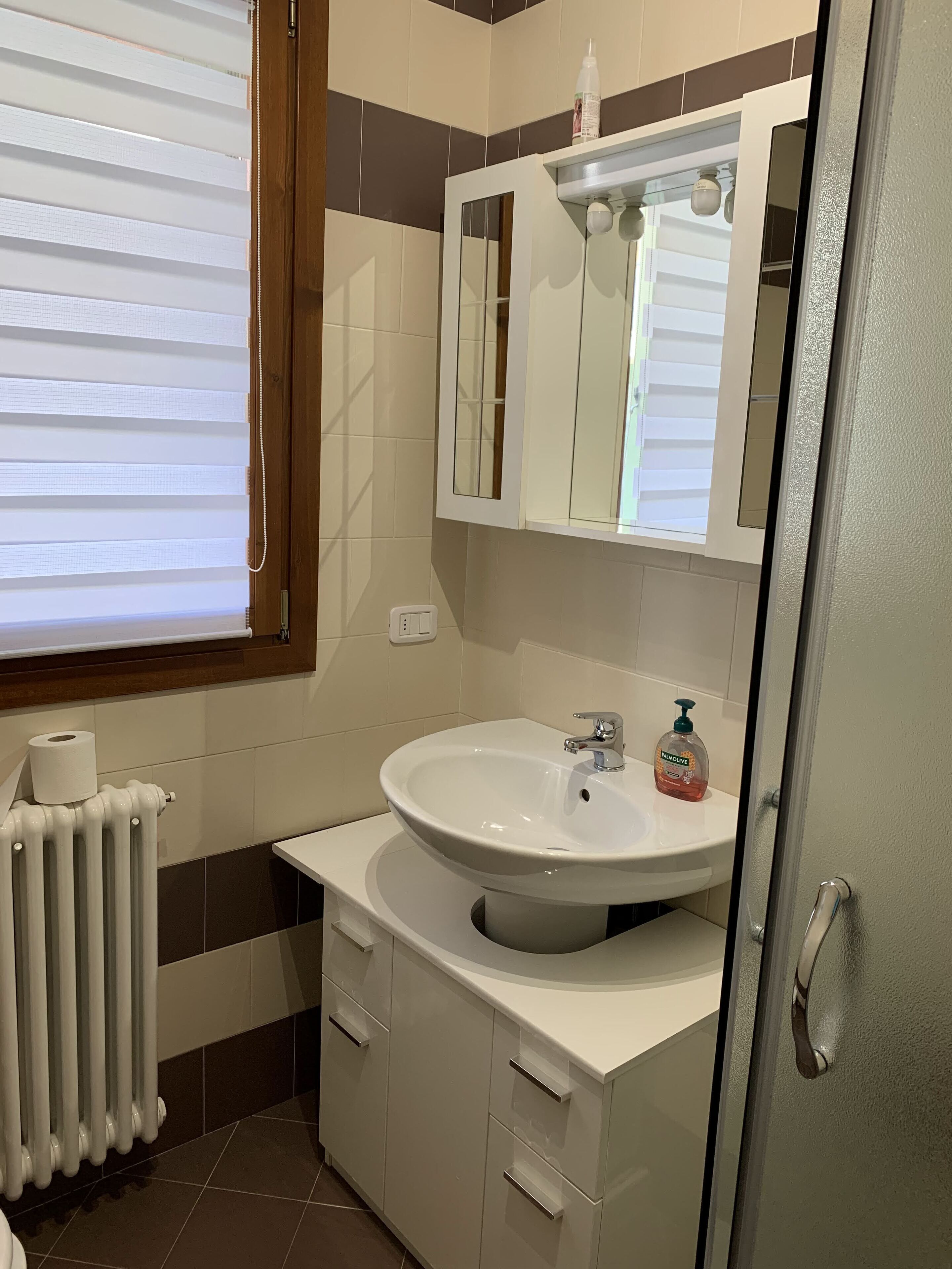 Une salle de bain avec un lavabo blanc, un miroir et des toilettes.
