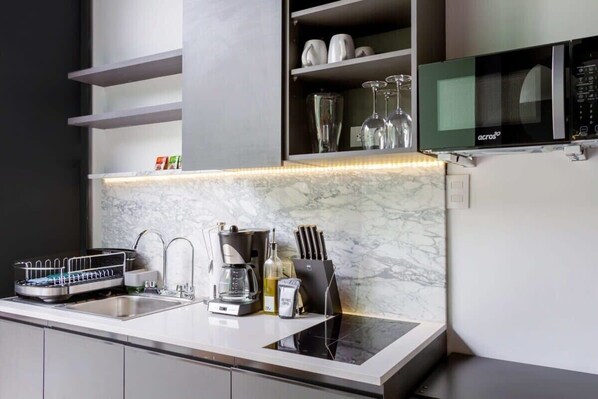 A modern kitchen with a built-in microwave, a dish drying rack, a coffee maker, and a knife block. - w* | Lively Loft w/ Modern Deco in Roma Norte (Ciudad de México)