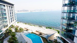 A modern building with a swimming pool and a view of the sea.