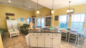 A kitchen with a central island, white cabinets, and a dining area with a table and chairs.
