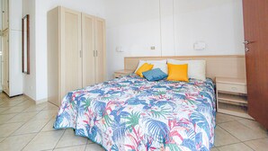 Ein Schlafzimmer mit Bett, Kleiderschrank und einer Tür.