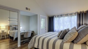 A bedroom with a bed, a desk, and a chair. - Sunset Rentals | Treetops 6104 (Hilton Head Island)