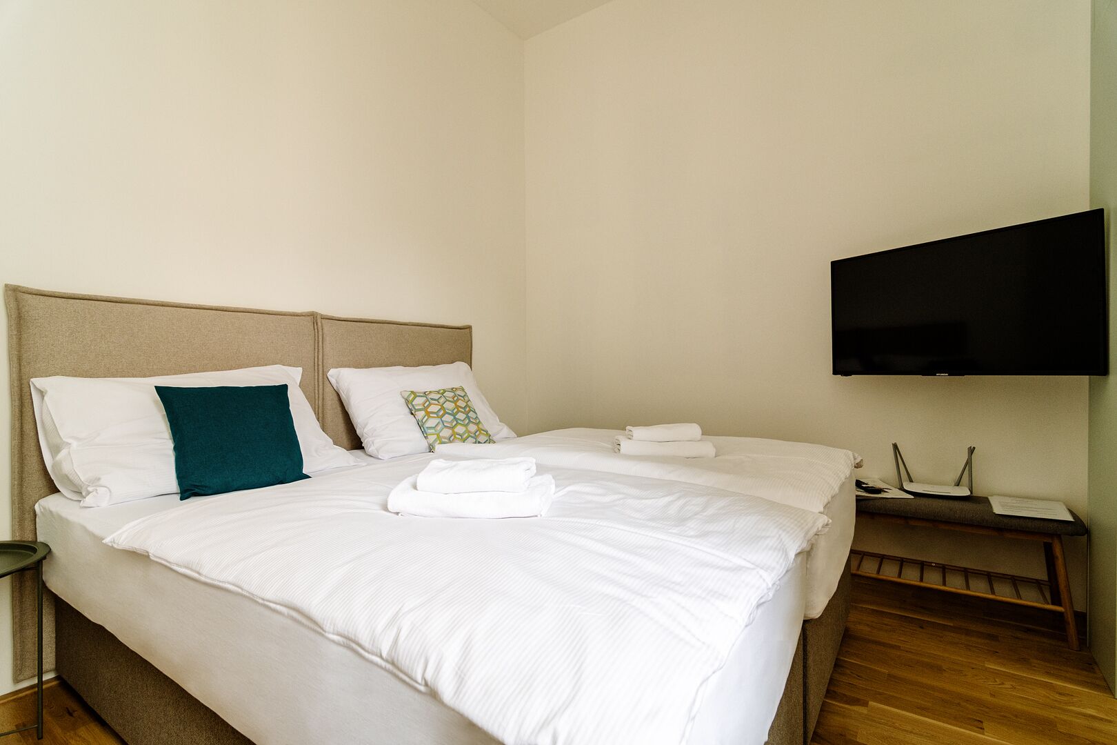 Une chambre d’hôtel avec deux lits, un téléviseur à écran plat et un plancher en bois.