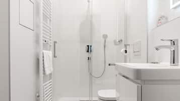 A modern bathroom with a shower, toilet, and sink.