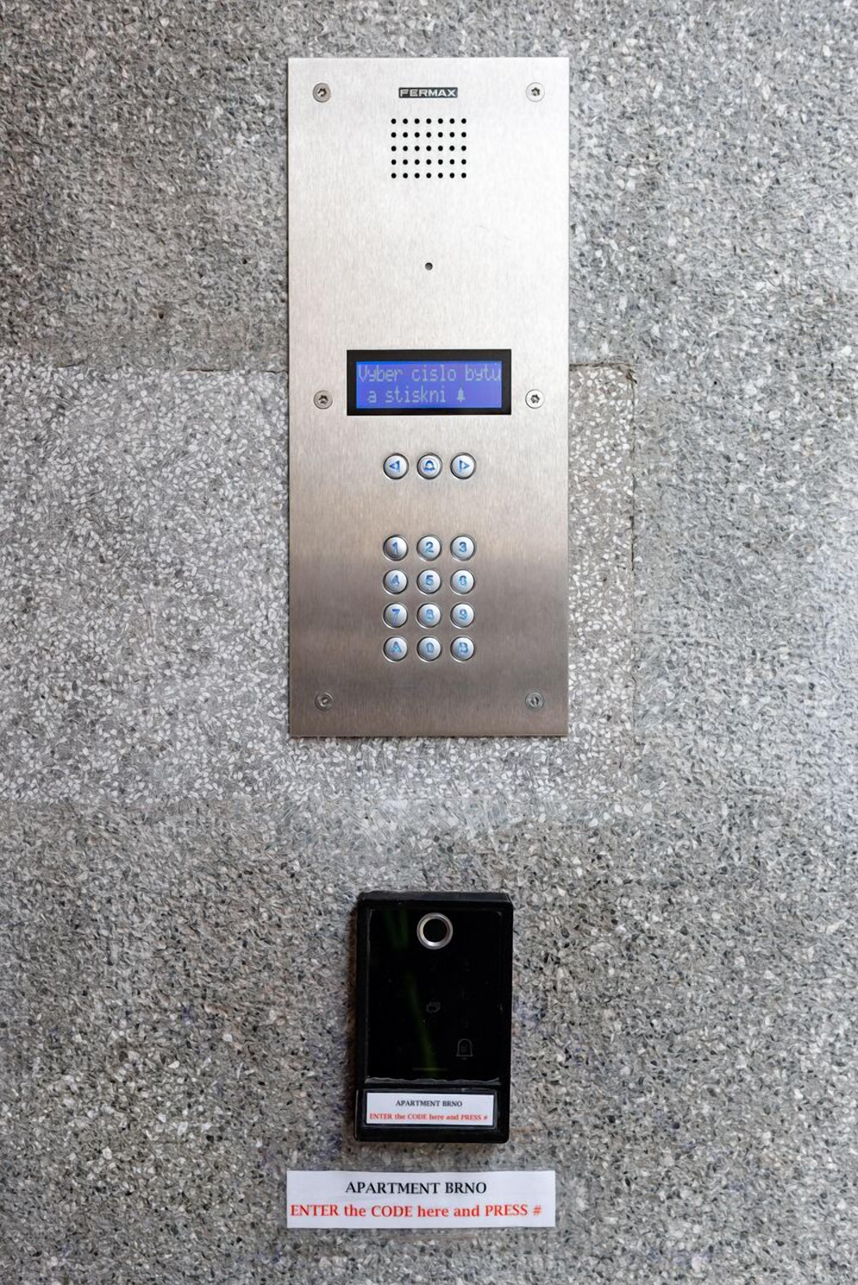 A keypad with a digital display and a card reader for apartment access.